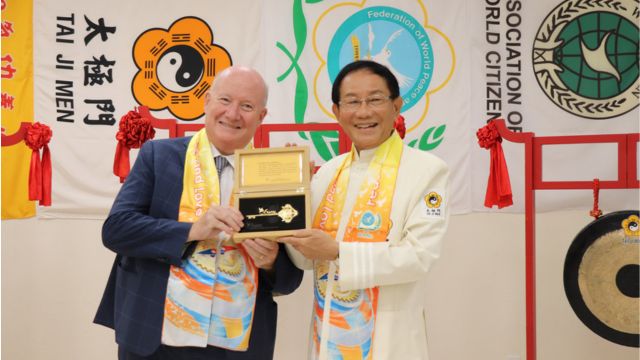 Bitter Winter’s editor-in-chief Massimo Introvigne is presented with the symbolic “Key to the Heart” by Dr. Hong after ringing the Tai Ji Men Bell of World Peace and Love.